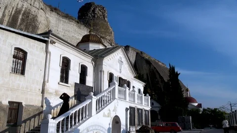 Priest descends staircase of present cave monastery of St. Klimento. Video stock 106062244