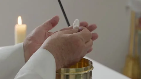 Priest Hands Holding Communion Host Over Ciborium at Mass Stock Footage 346470191