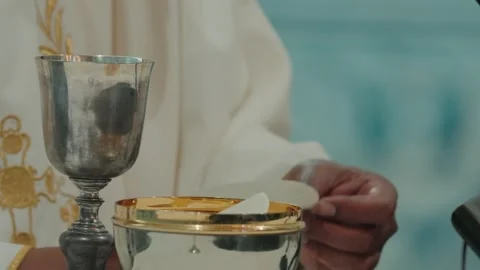 Priest Hands Placing Communion Host In Ciborium Beside Chalice During Catholic Stock Footage 337913367