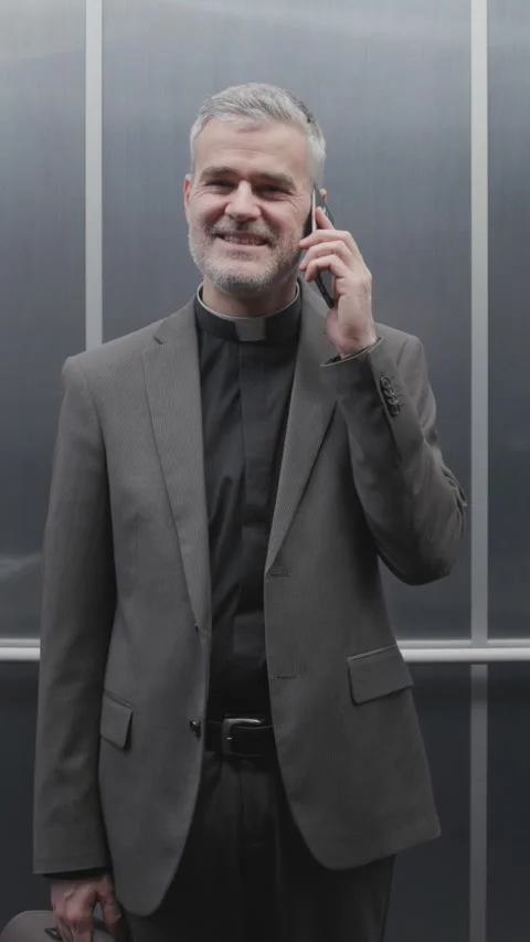 Priest having a phone call in the elevator Stock Footage 307325132