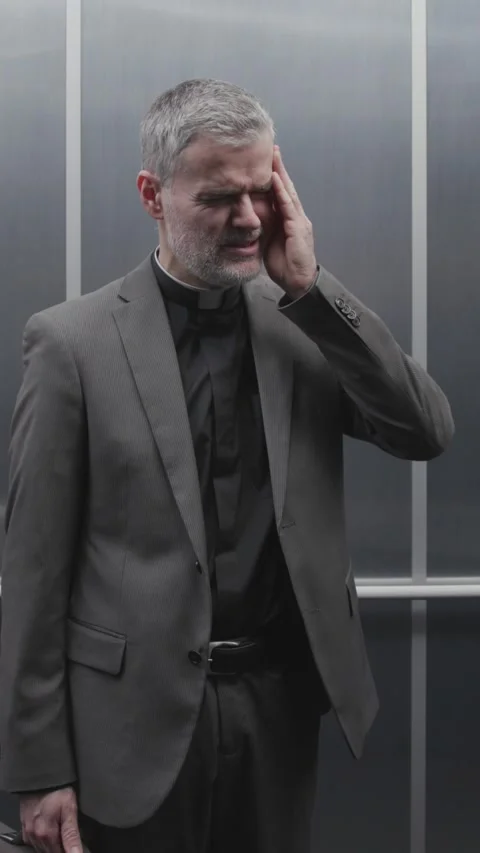 Priest with headache in the elevator Stock Footage 307324728
