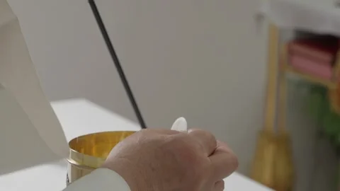 Priest holds communion host up during consecration at catholic mass Stock Footage 346111424