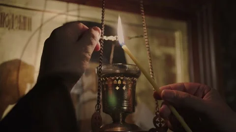 The priest lights an ancient copper lamp in the church Stock Footage 147177197