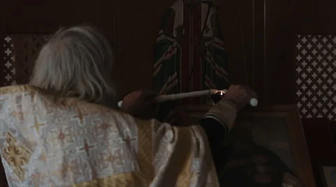 The priest lights two candles Stock Footage 54119188