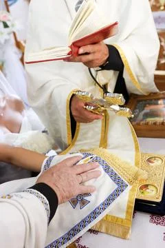 Priest performs the Orthodox wedding rite, blessing the newlyweds with the Go Stock Photos