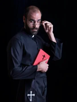 Priest praying with a bible, looking at camera Stock Photos