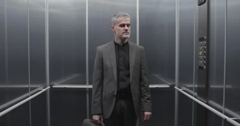 Priest praying in the elevator Stock Footage 307324211