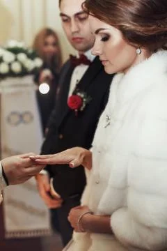 Priest put the wedding ring on bride's hand Stock Photos