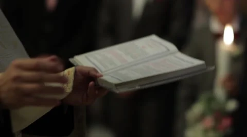 Priest read from the Scriptures during a religious weddings held in the small  Vídeos de archivo 60055679