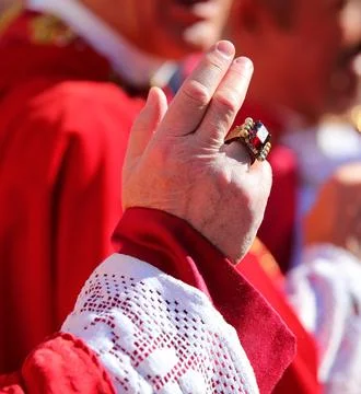 Priest with a ring with a large red ruby while giving the blessing to the f.. 스톡 사진
