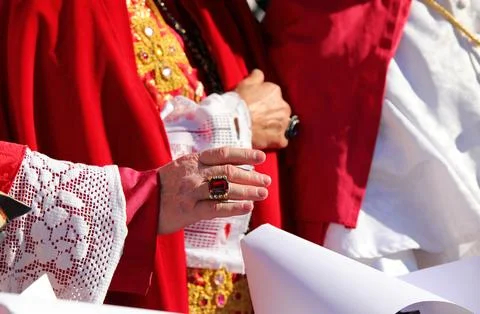 Priest with a ring with a red ruby while giving the blessing to the faithful Stock Photos