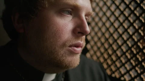 Priest Sitting inside Confessional Booth during conversation with Penitent Stock Footage 318340143