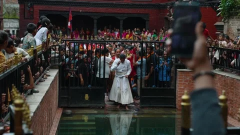 Priests Diving into Pond during Gai Jatra in Harisiddhi, Nepal Stock Footage 318718105