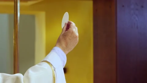 Priest's hand during the eucharist with the sacred form Stock Footage