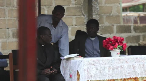PRIESTS SITTING AT A TABLE - SPEAKER AT A CEREMONY Stock Footage 60115471