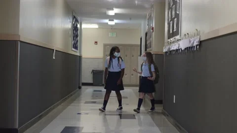 Primary and Elementary school children wear masks walking in the hall at school Video stock 139655815