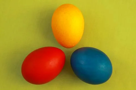 Primary colors Easter eggs green background Stock Photos