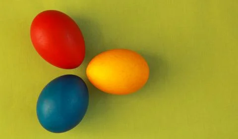 Primary colors Easter eggs green background Stock Photos