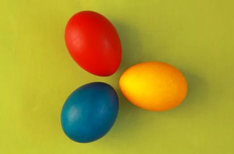 Primary colors Easter eggs green background Stock Photos