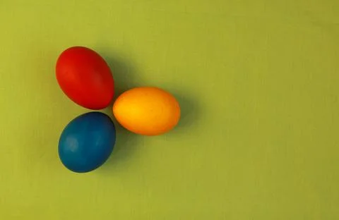 Primary colors Easter eggs green background Stock Photos