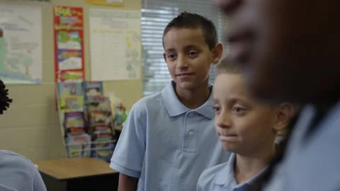 Primary or Elementary students in uniforms listen to teacher give instructions Stock-Footage 141757504