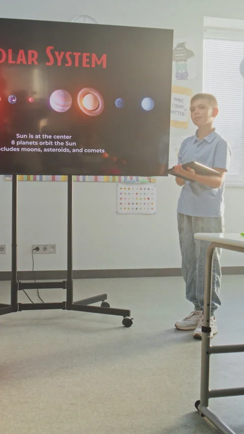 Primary School Boy Showcasing Knowledge of Astronomy in Front of Class and Stock Footage 315538585