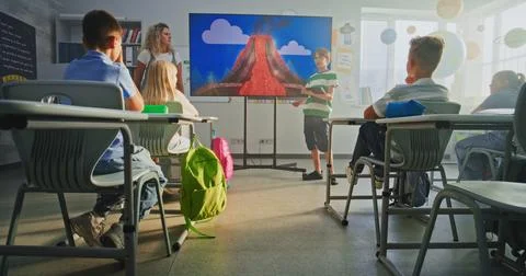 Primary School Boy Showcasing Knowledge of Geology in Front of Class and Teacher Stock Photos