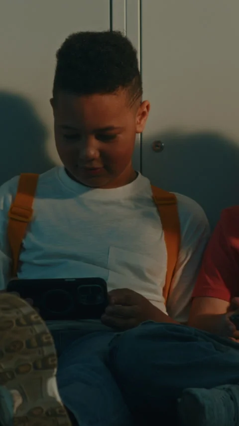 Primary School Classmates Sitting on Corridor Floor With Digital Gadgets Stock Footage 342036690