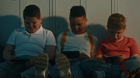Primary School Classmates Sitting on Corridor Floor With Digital Gadgets Stock Footage 342037116