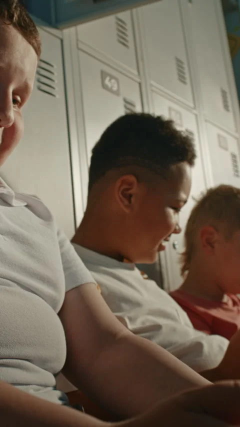 Primary School Classmates Sitting on Floor Beside Personal Lockers with Handheld Stock Footage 342020474