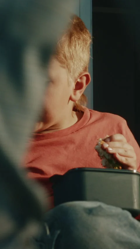 Primary School Student Enjoying Packed Lunch with Reusable Food Container and Stock Footage 342029835