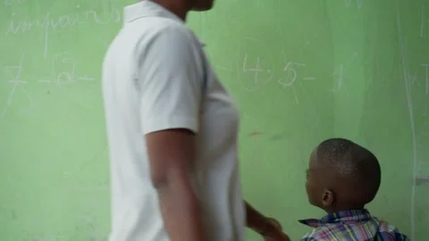 Primary school student solving math problem on chalkboard in Haiti Stock Footage 320928833
