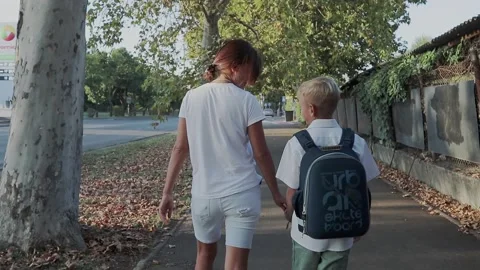 Primary School Student Walking to School with Mother Stock Footage 139034322