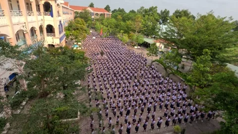 Primary school students are dancing ceremony in a schoolyard. Can Tho, Vietnam Stock Footage 243418075