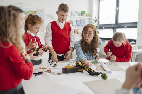Primary school students learning robotics and technology during STEM class. Stock Photos