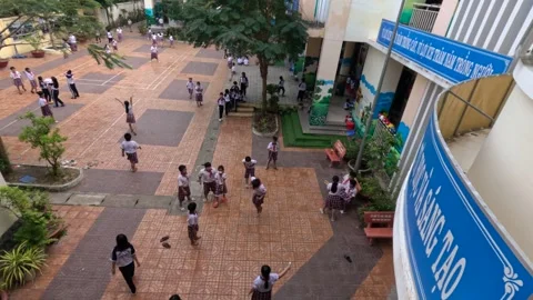 Primary school students in a schoolyard during a break. Can Tho, Vietnam 스톡 동영상 246987753