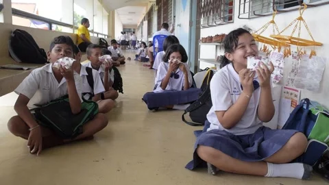 Primary School Students Sitting on the Floor and Joyfully Drinking Milk Stock Footage 156755261