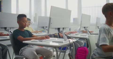 Primary School Students Working on Computers. Teacher Guiding Diverse Kids in Stock Footage 316297866