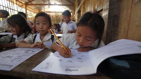 Primary schoolchildren with exercise book in simple classroom Video stock 121094674