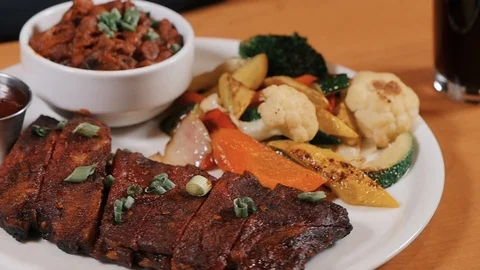 Prime rib served with vegetables bacon sauce and mashed paprika Stockbeeldmateriaal 107525697