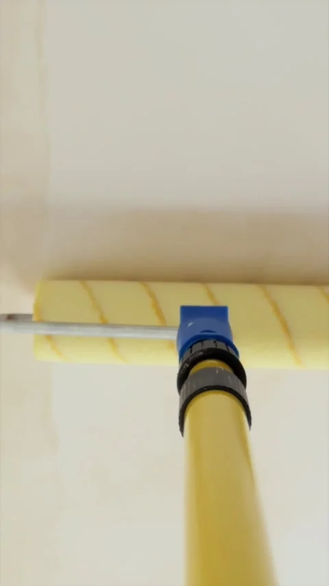 Priming apartment ceiling with wet roller on extension pole Stock Footage 340404947