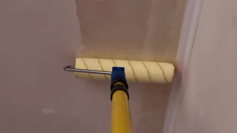Priming high apartment ceiling with roller on telescopic extension pole Stock Footage 340403921