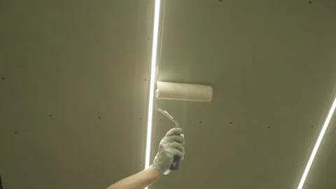 Priming the plasterboard ceiling with a roller Stock Footage 323116513