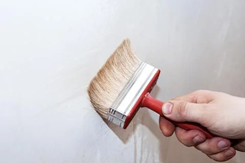 Priming of the wall with a brush Stock Photos