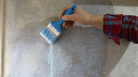 Priming the wall surface with a paintbrush 库存照片