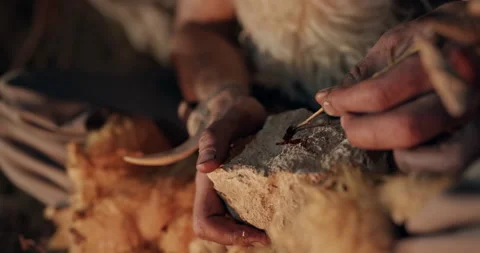 Primitive hunter writing or drawing in blood on a stone by the light of a Stock Footage 140933434