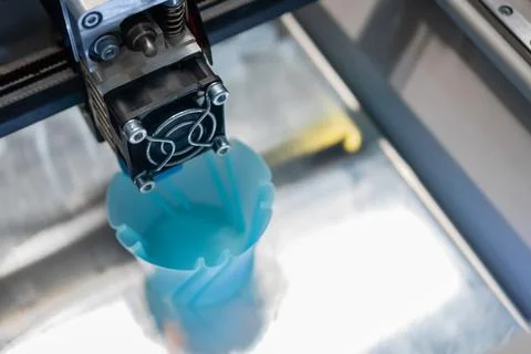 Print head of 3D printer machine printing blue plastic model - close up 스톡 사진