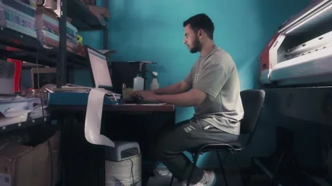Print Shop Owner Typing on Computer and Smiling at Camera Stock Footage 340403138