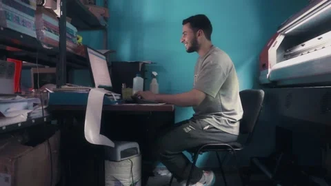 Print Shop Owner Typing on Computer and Smiling at Camera Stock Footage 340403154