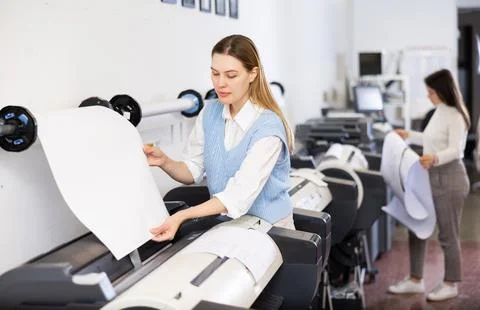 Print worker controlling printing process on modern offset machine in print shop Stock Photos